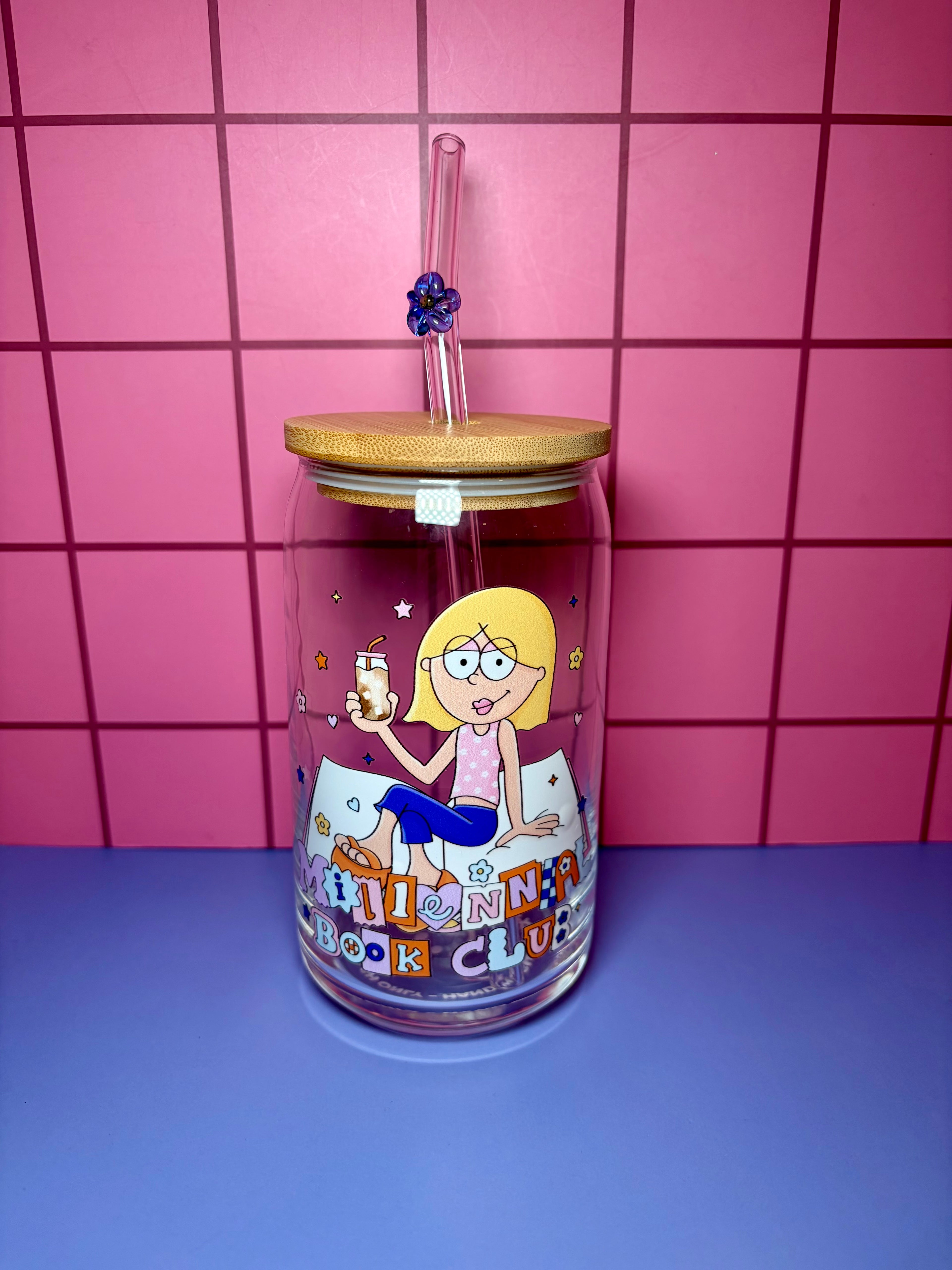 Glass tumbler with cartoon character and text on a pink tiled background