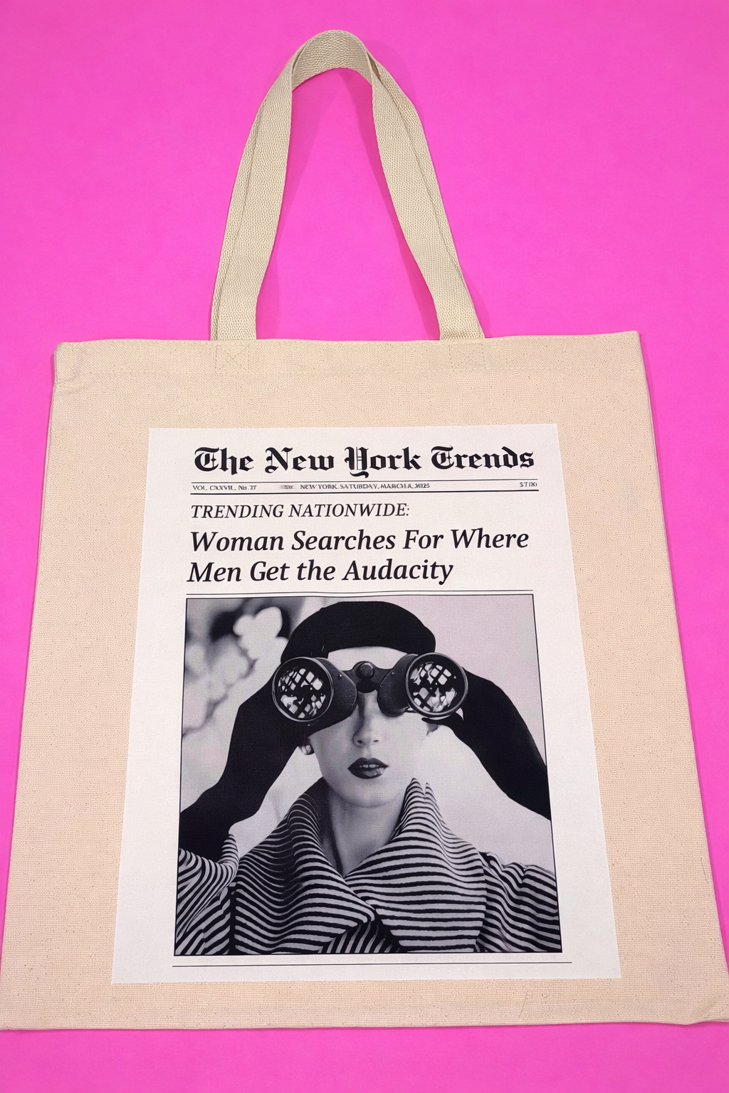 Tote bag with a newspaper design featuring a woman with binoculars and title "Woman Searches for Where Men Get the Audacity"