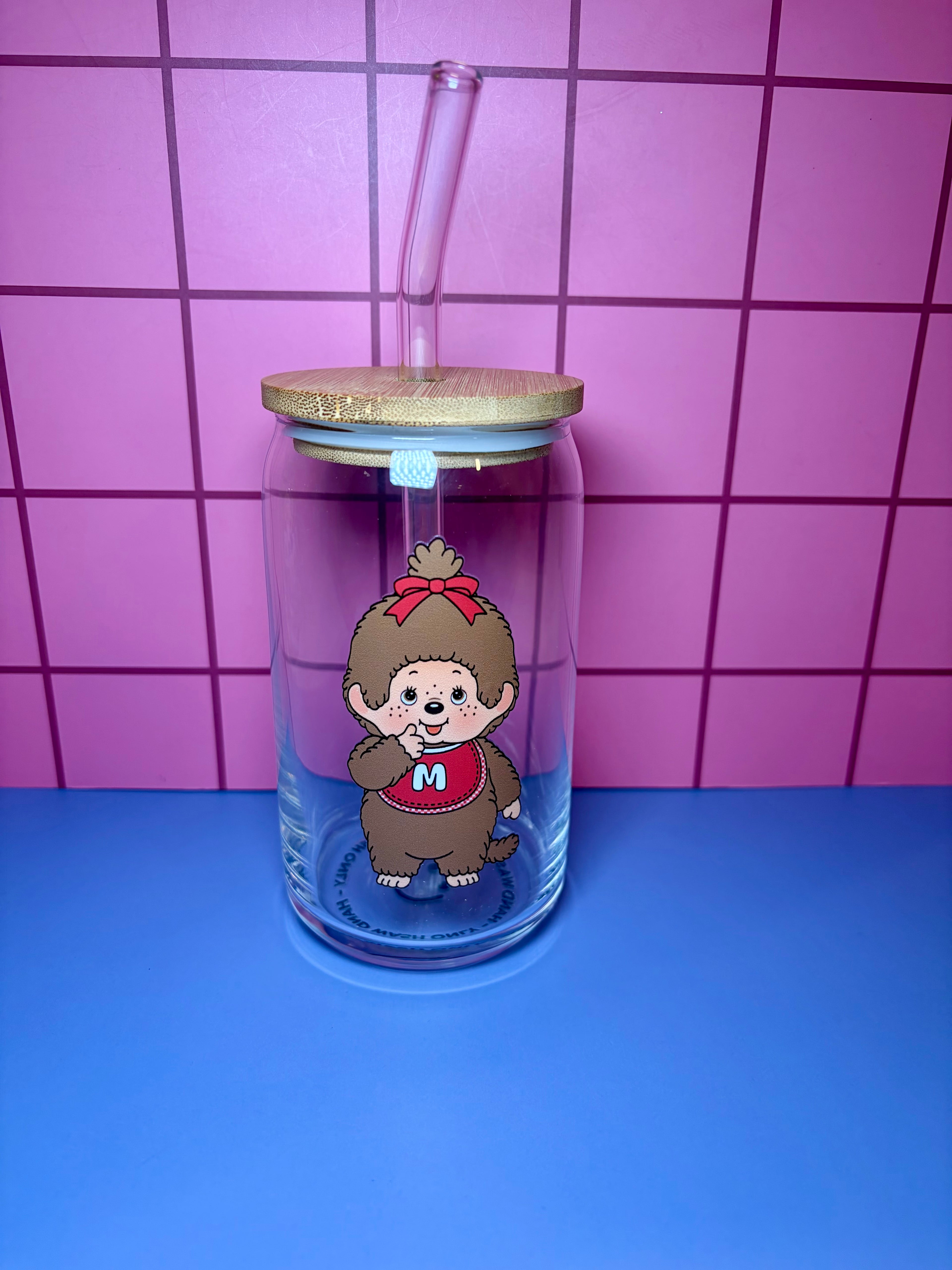 Clear tumbler with a cartoon monkey character on a pink and blue tiled background