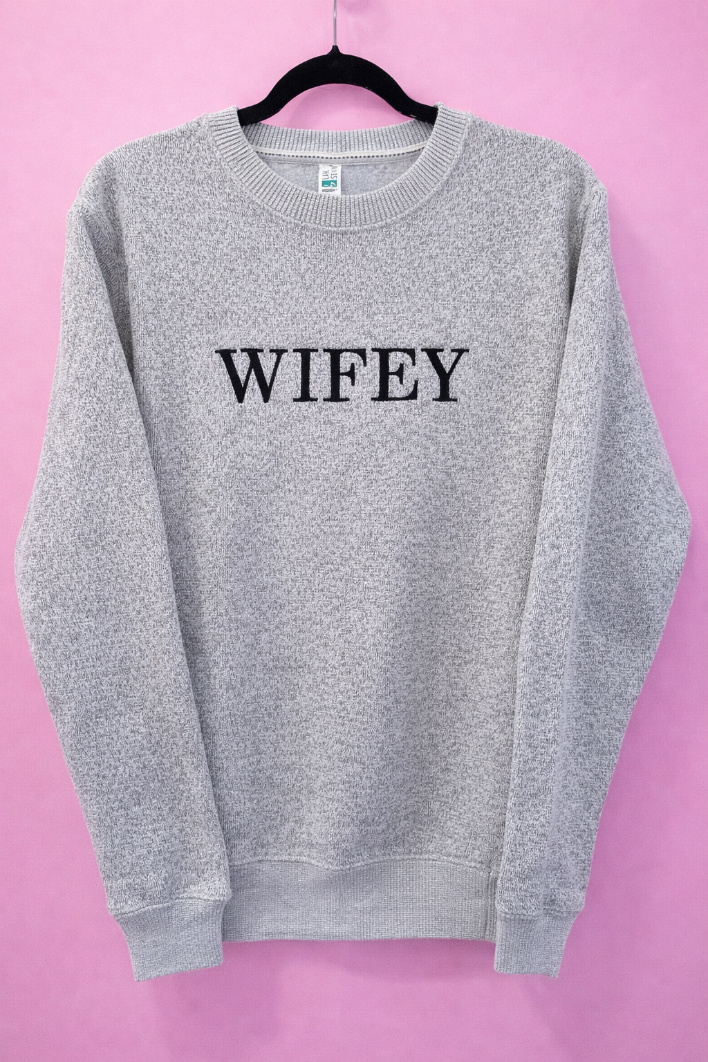 Gray sweatshirt with 'WIFEY' text on a pink background