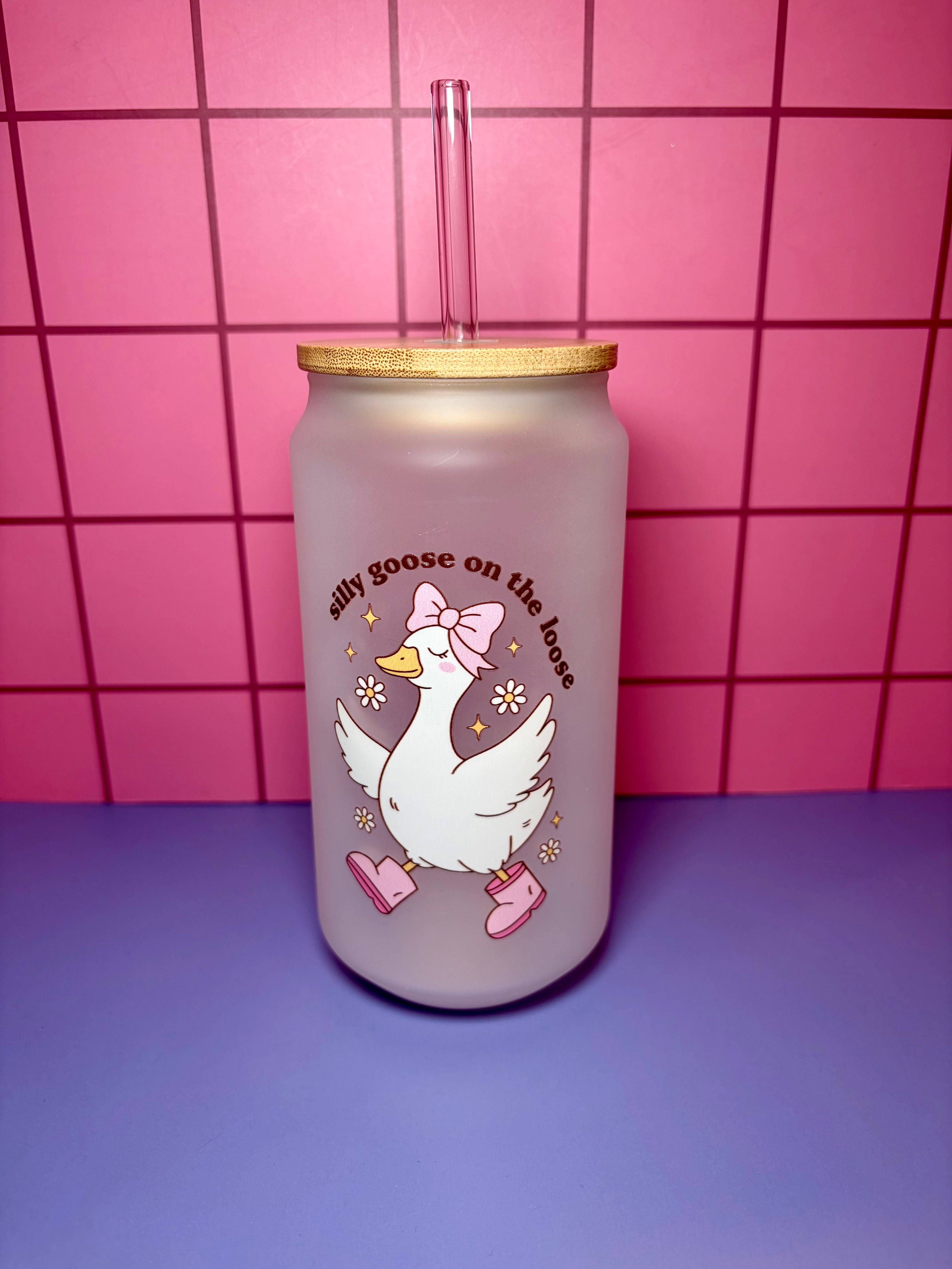 Tumbler with a cartoon goose design on a pink tiled background
