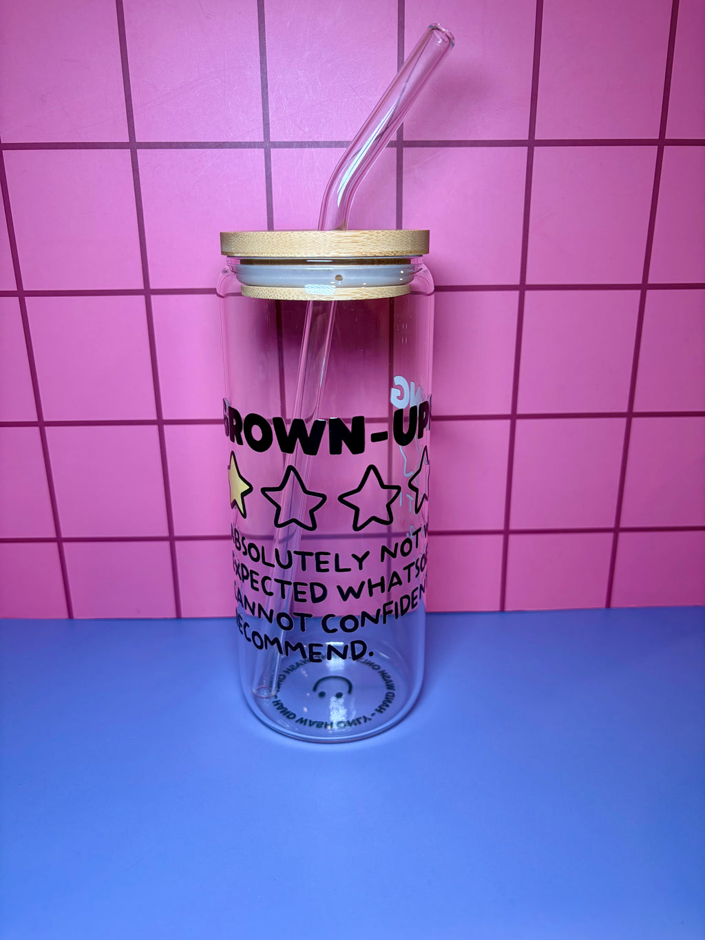 Clear tumbler with text and stars against a pink tiled background