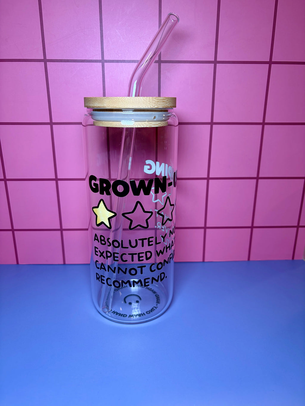 Clear tumbler with text and star designs on a pink and blue checkered background