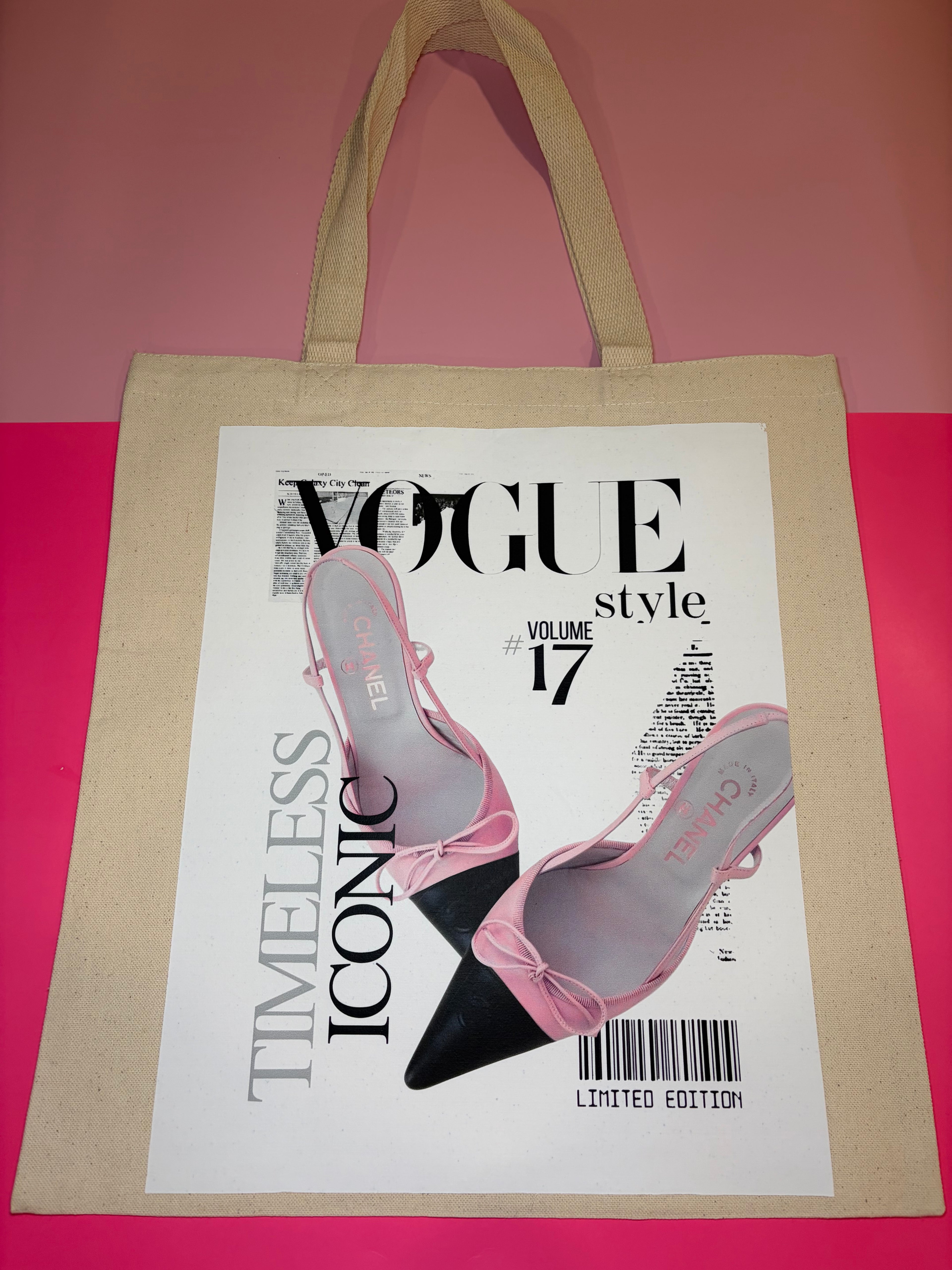 Beige tote bag with Vogue magazine cover featuring pink high heels on a white background