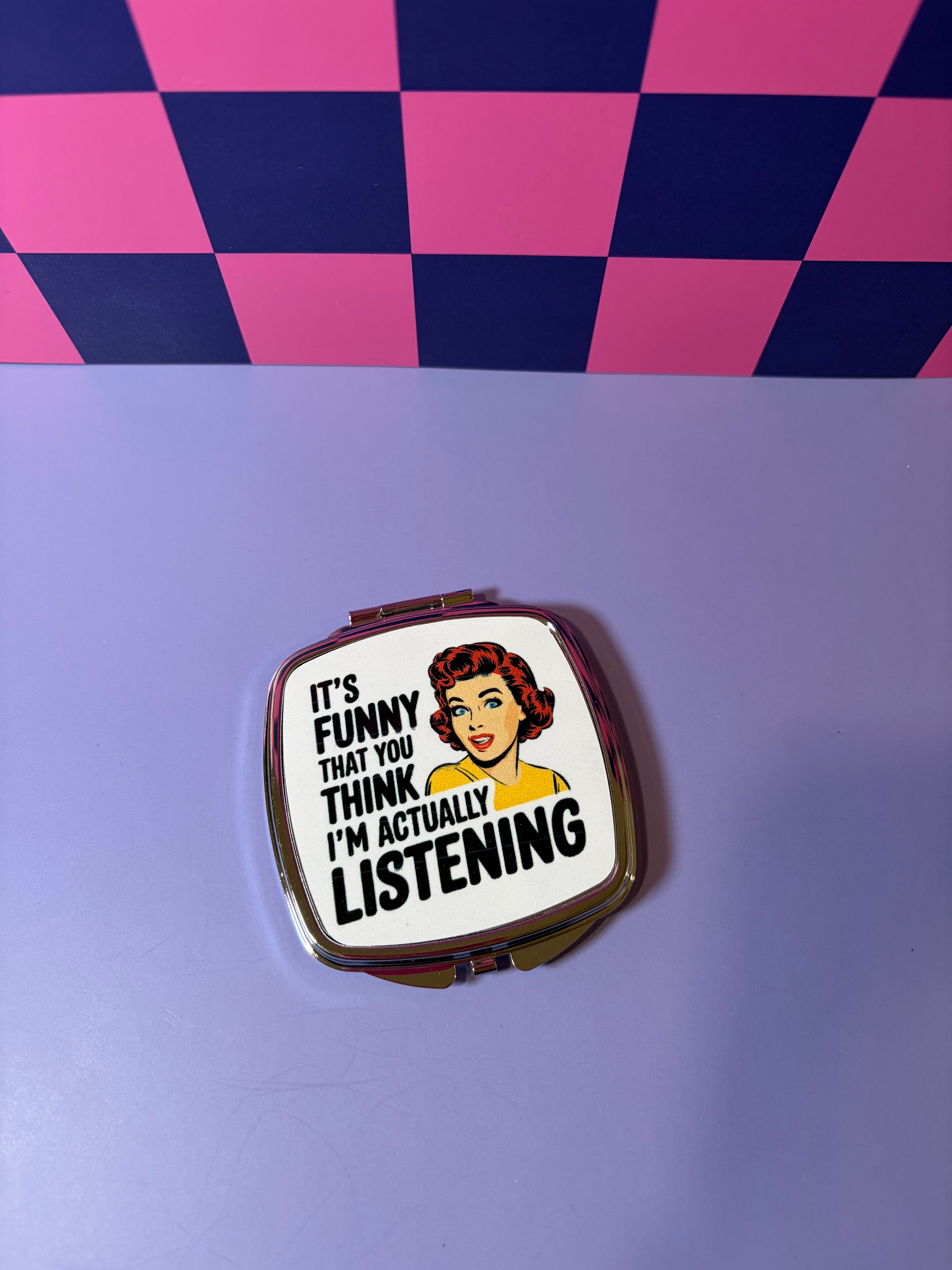 Compact mirror with text "It's Funny That You Think I'm Actually Listening"