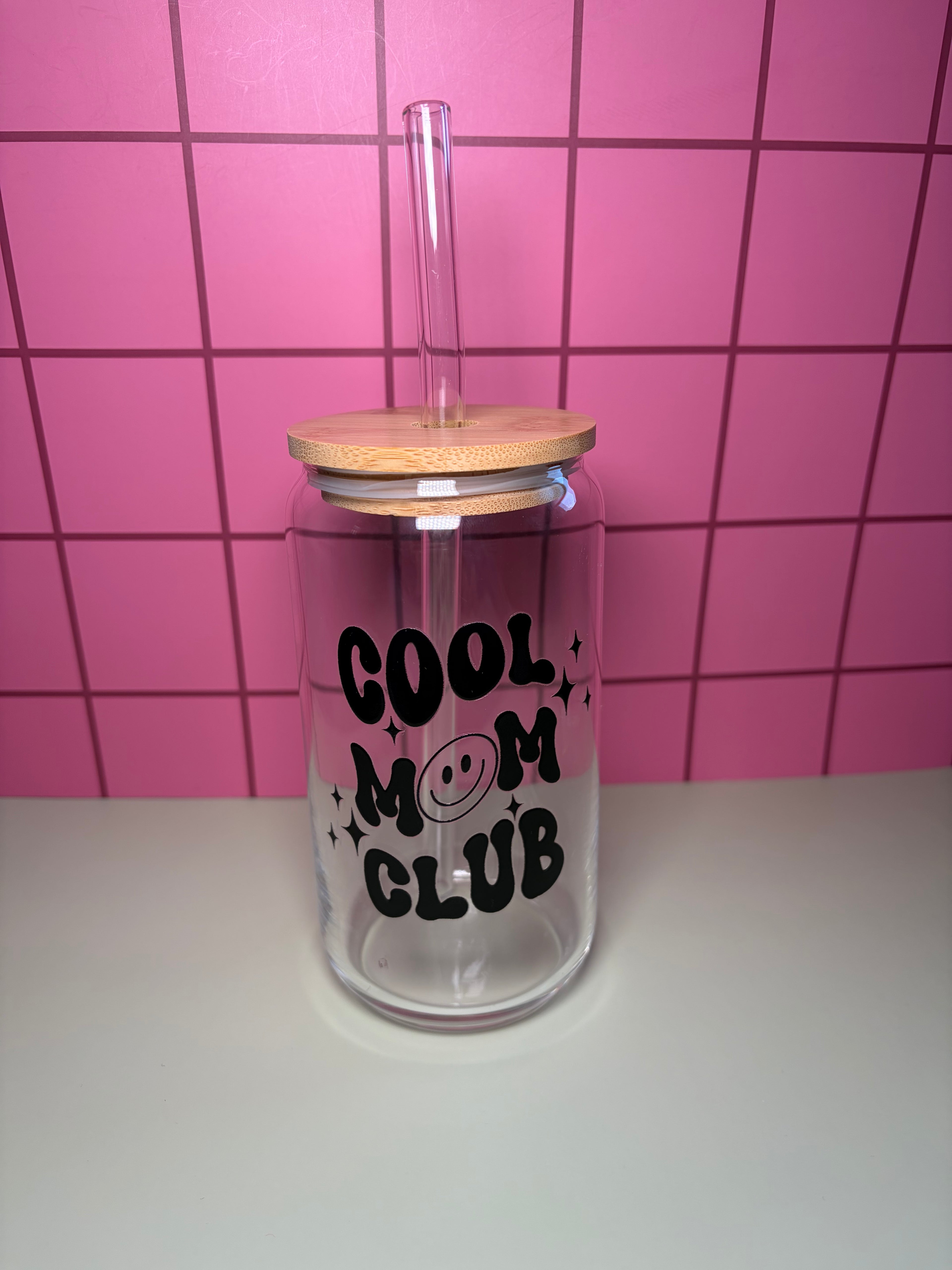 glass can with wooden lid and glass straw that has a decal in black that says cool mom club 