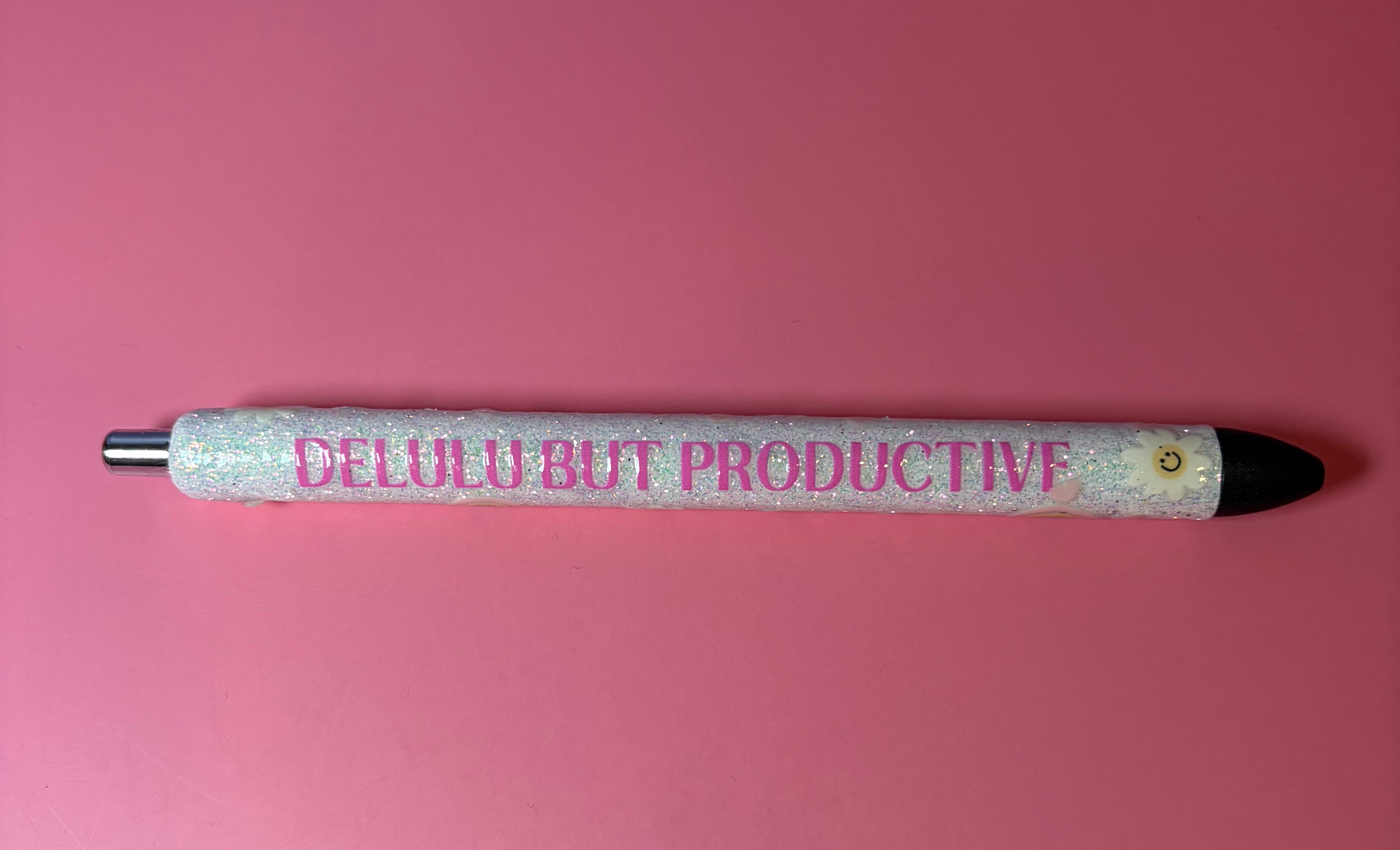 Pen with 'DELULU BUT PRODUCTIVE' text on a pink background