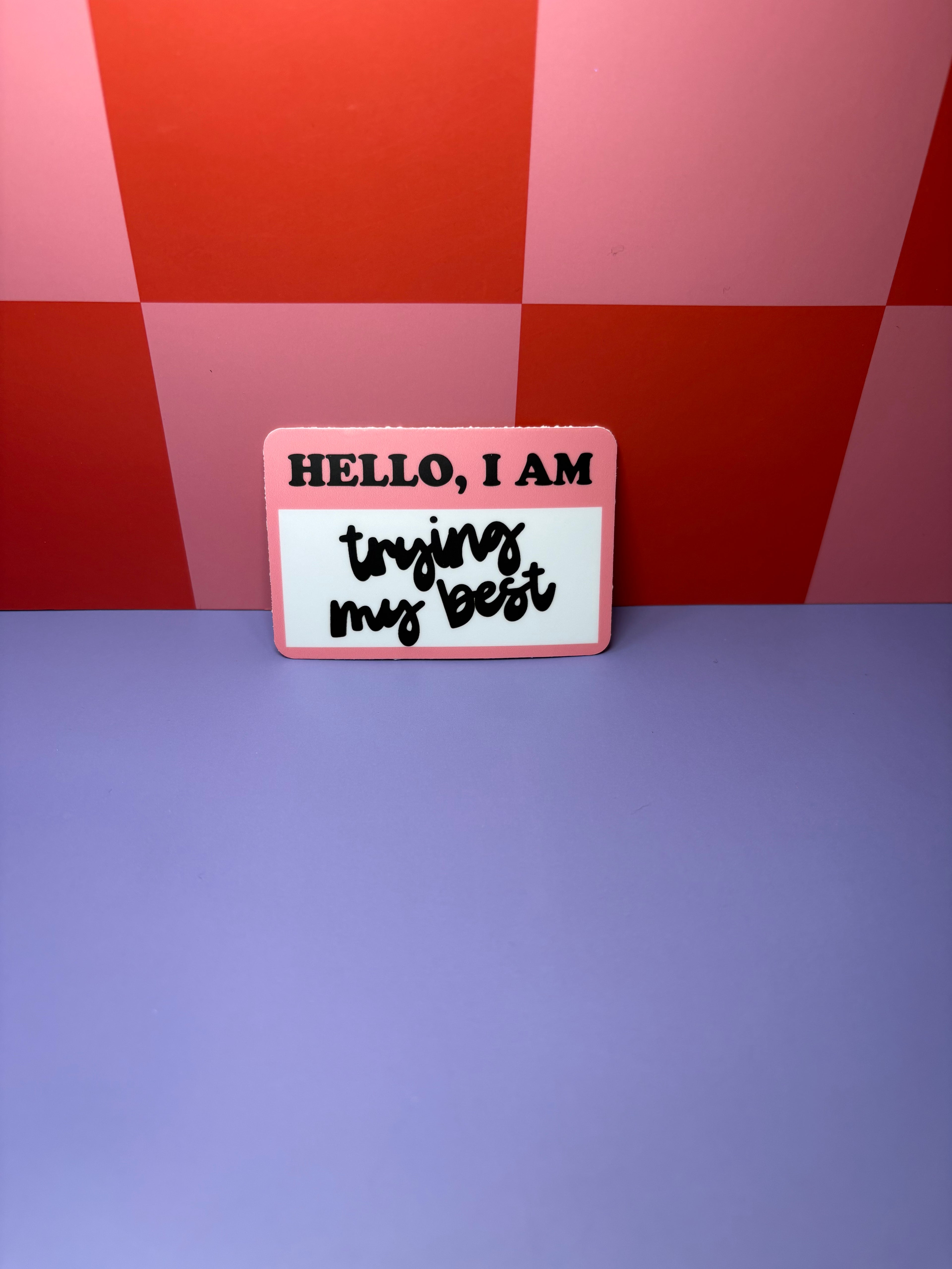 Pink and white nametag style sticker with "Hello, I Am Trying My Best" design