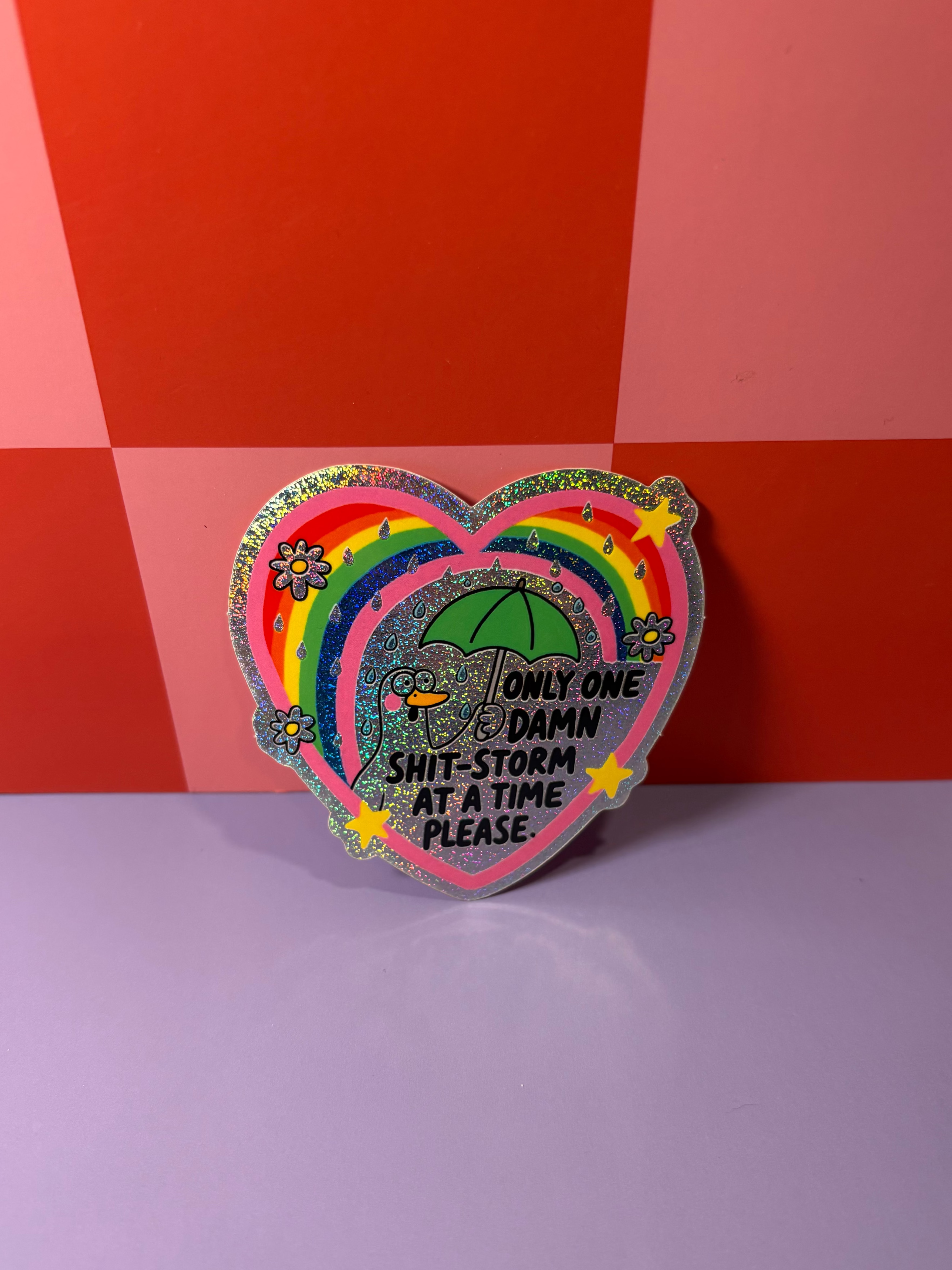 Rainbow sticker with "Only One Damn Shit-Storm At A Time Please" text