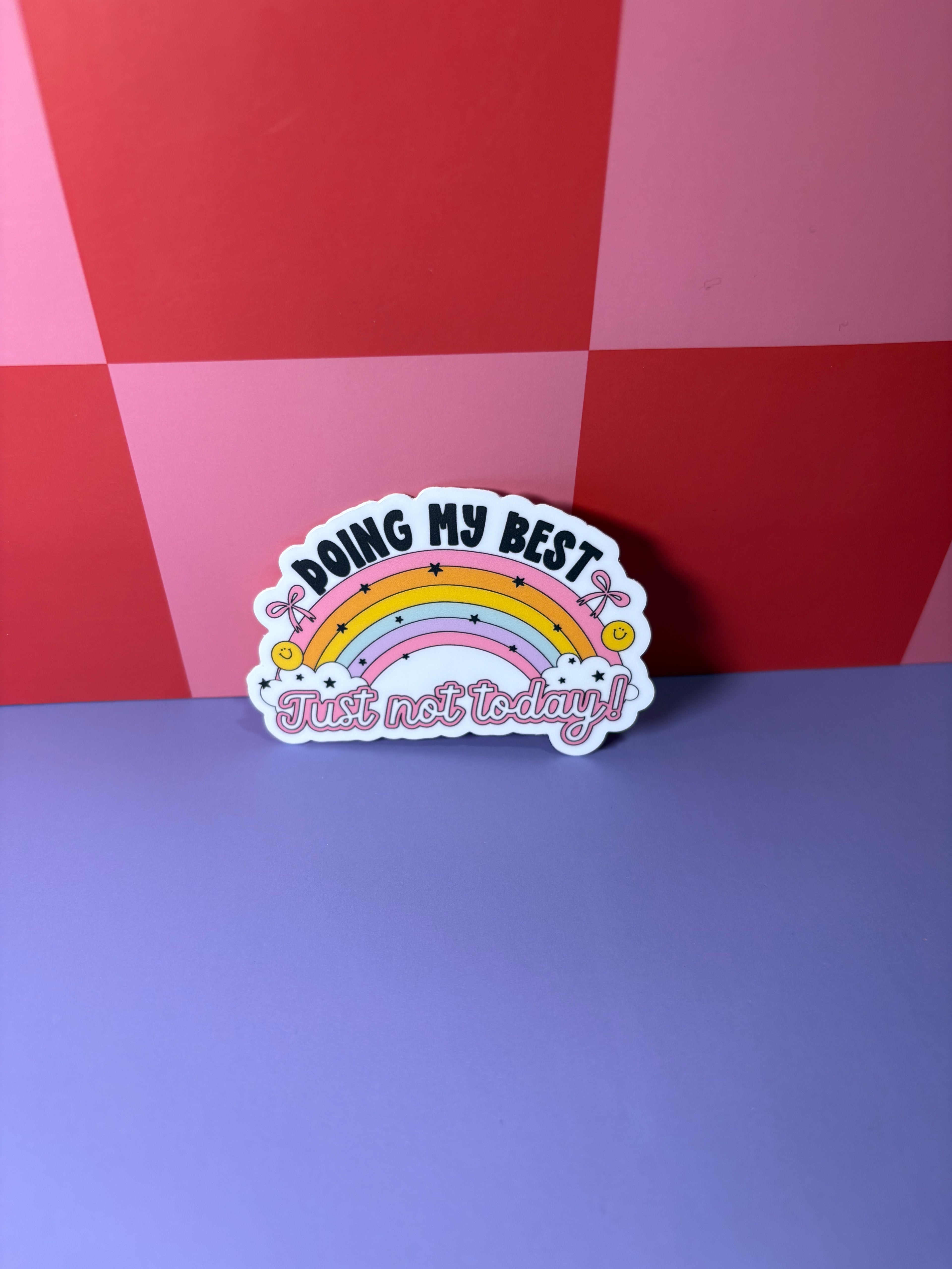 Sticker with rainbow design and "Doing My Best Just Not Today!" text on a red and purple checkered background