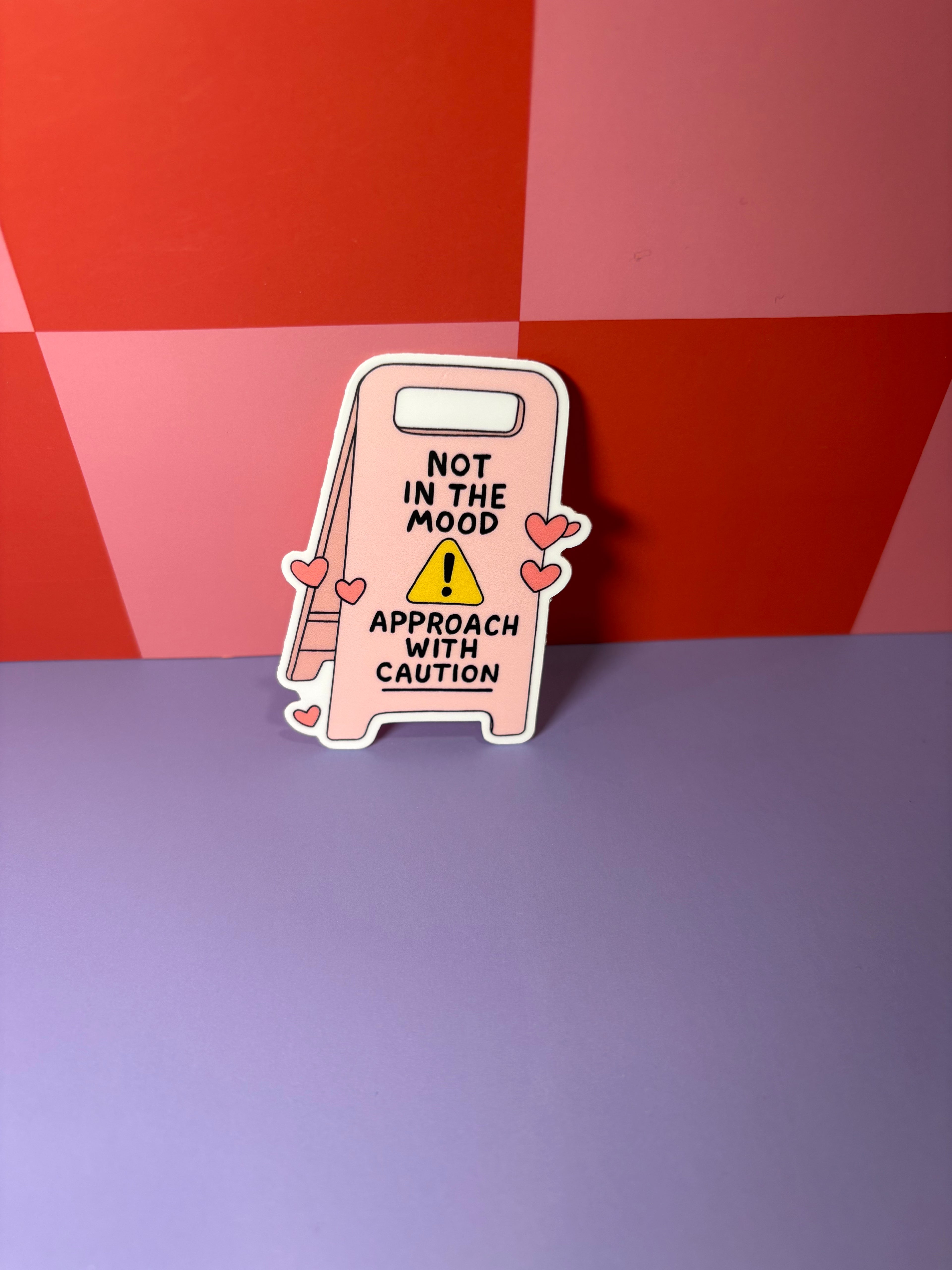 Pink caution sign with text "Not in the Mood Approach with Caution"