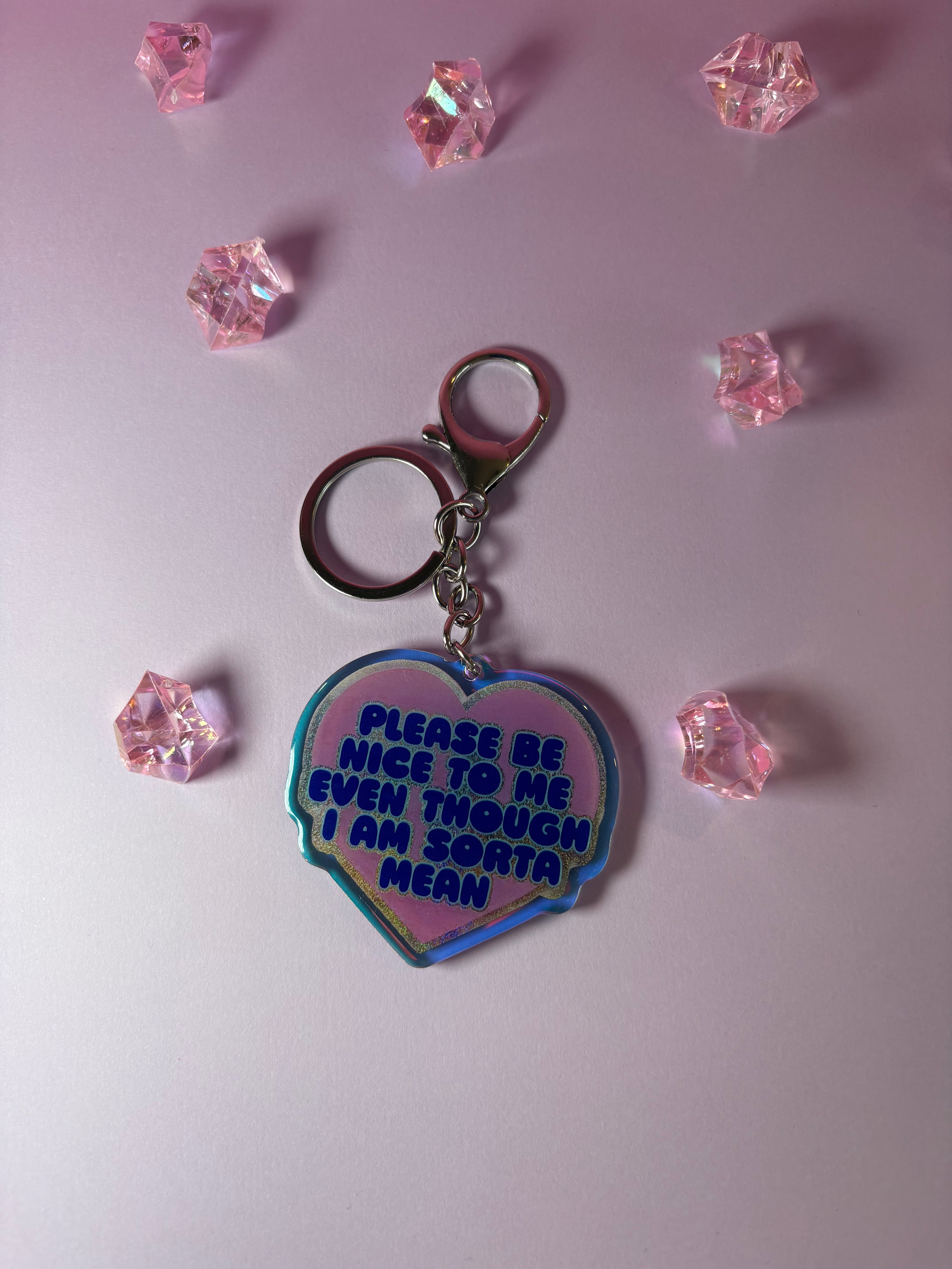 Heart-shaped keychain with "please be nice to me even though I am sorta mean" text