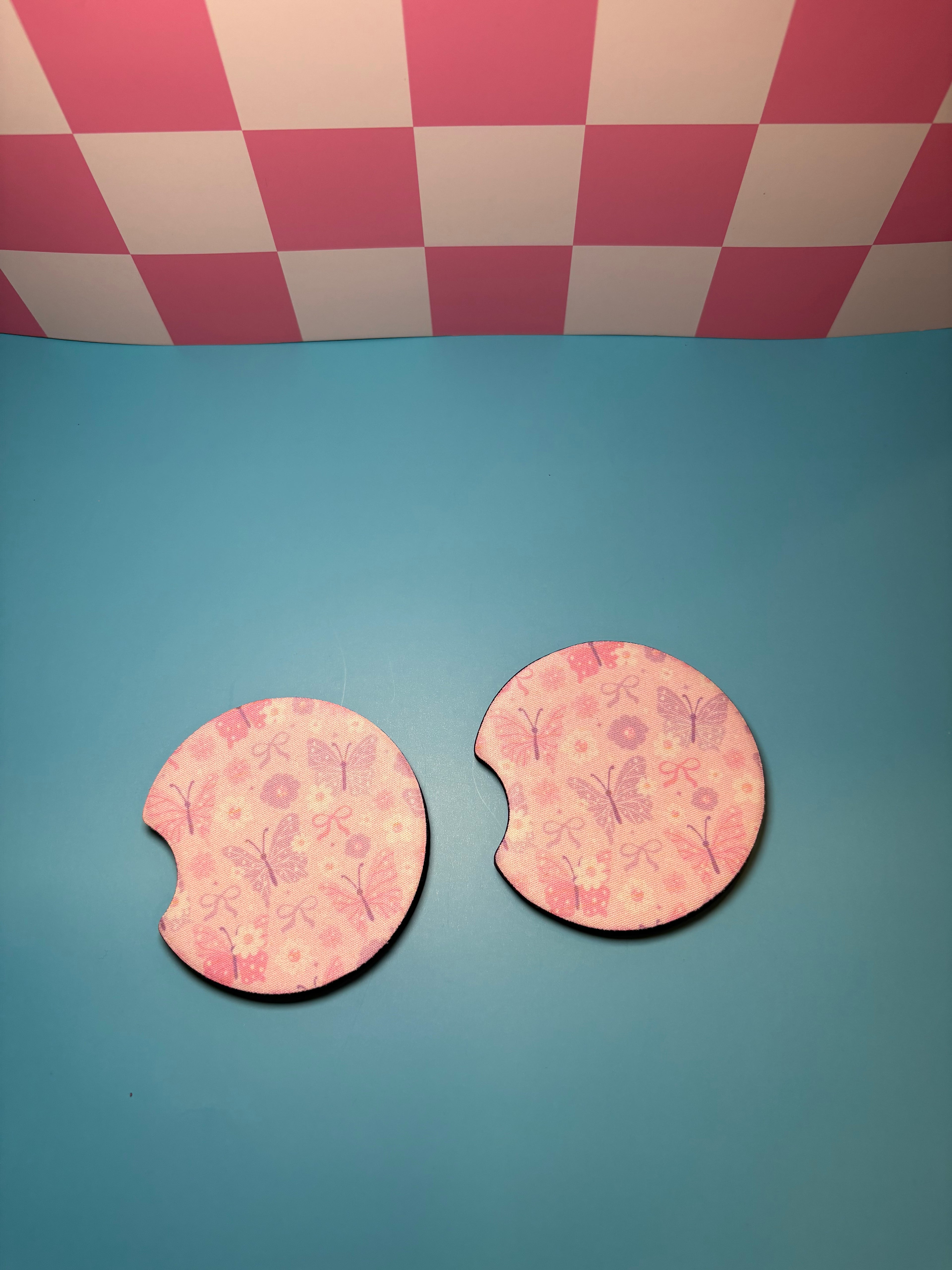 Two pink car coasters with floral patterns