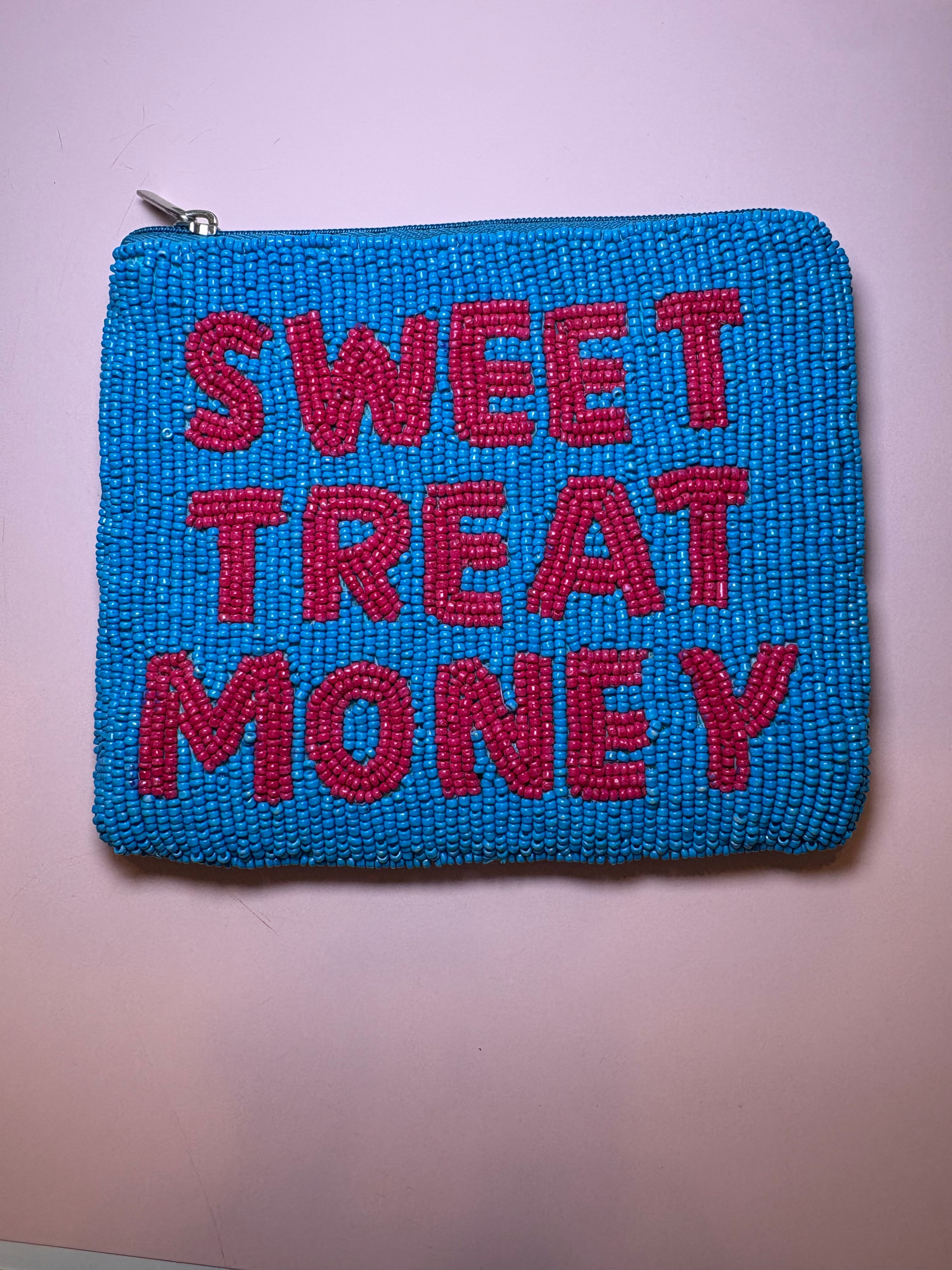 A square blue beaded pouch with the phrase 'SWEET TREAT MONEY' in raised red beaded letters, shown against a light pink background.