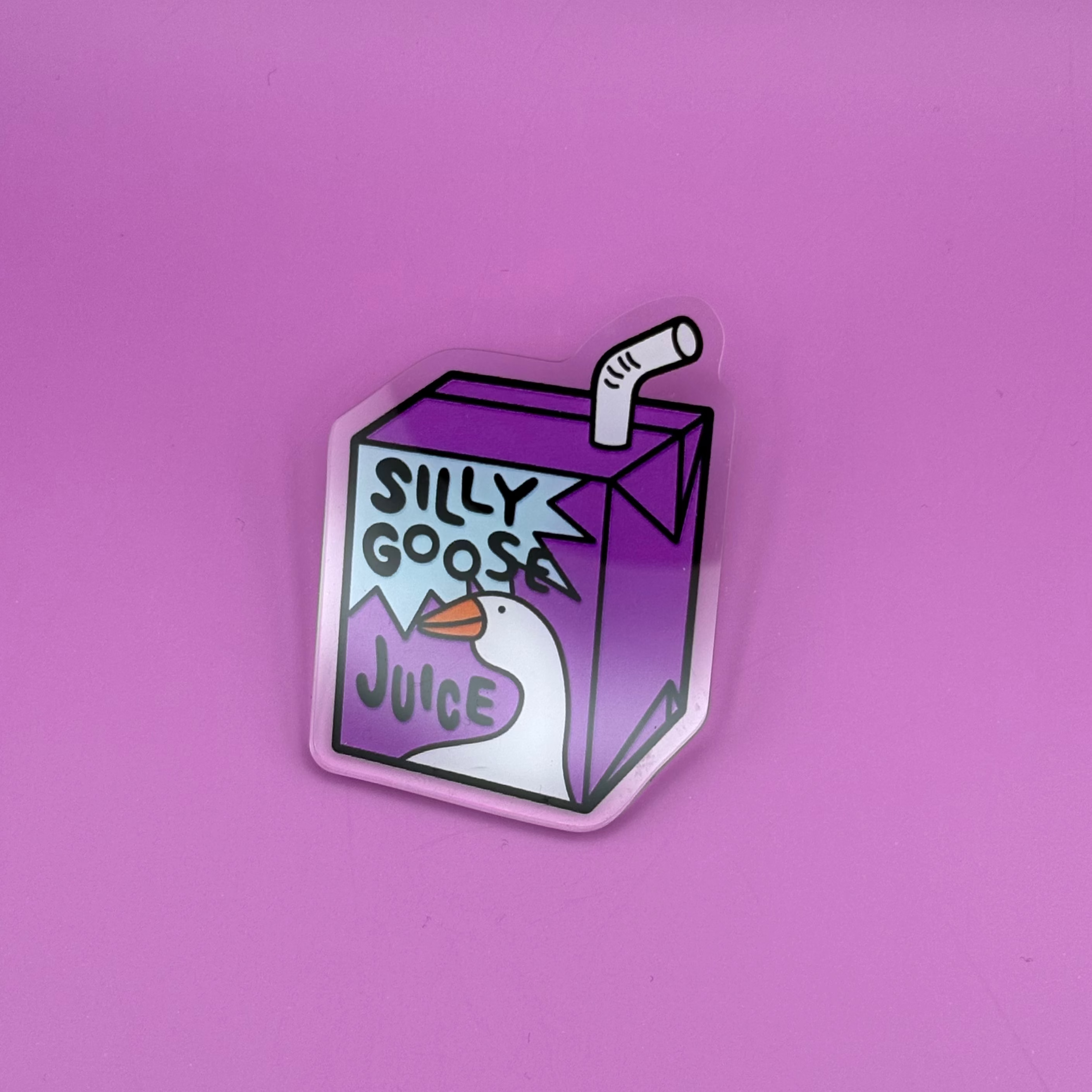 A die-cut sticker shaped like a purple juice box with a cartoon duck and the words 'SILKY GOOSEJUICE' on a solid pink background.
